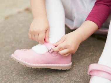 little girl doing up her new mothercare shoes