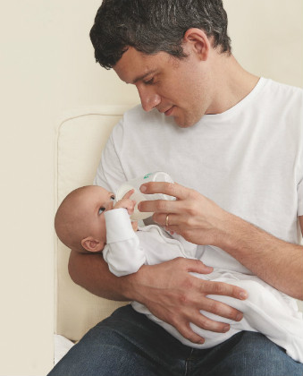 dad bottle feeding his baby