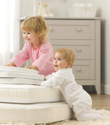 two little children playing on mothercare mattresses